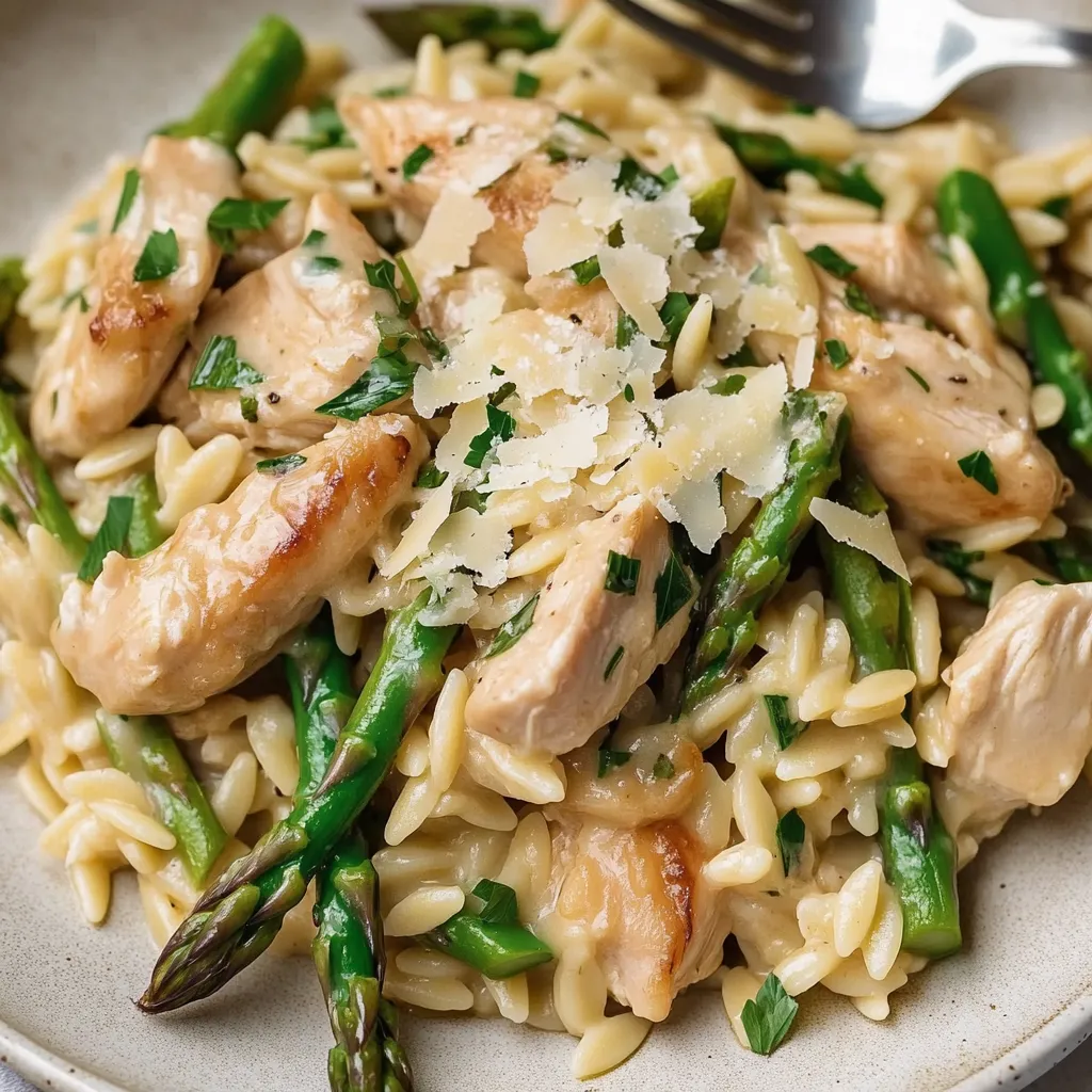 Ein Plate mit einer Mischung aus Chicken, Orzo und Asparagus.
