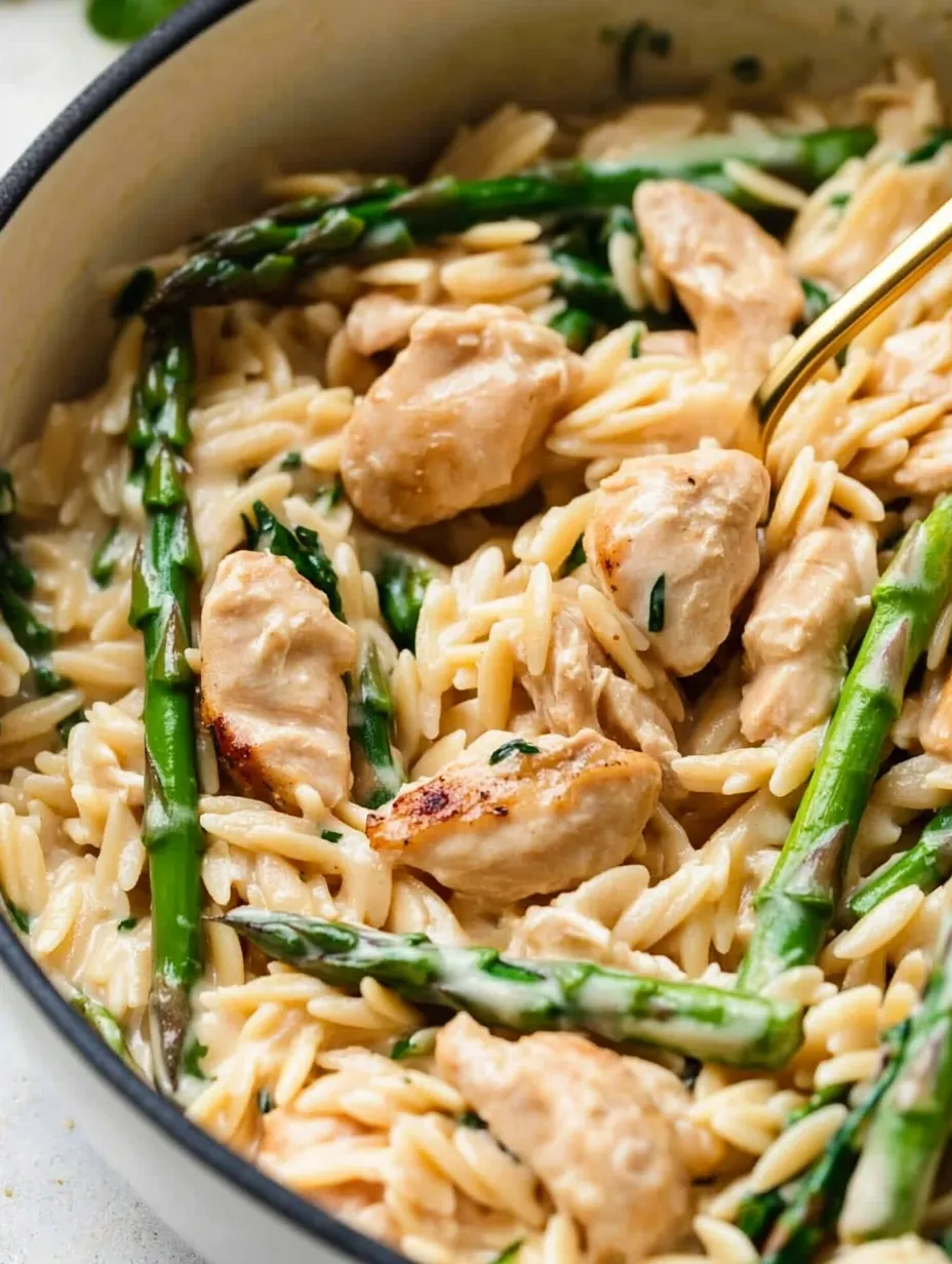Ein Bild von einer Ein-Bowl-Küche mit einer Mischung aus Reis, Zwiebeln, Asparagus, Kichererbsen, Chicken und Orzo.