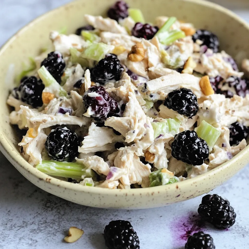 Ein Schüssel mit einer Mischung aus Hühnchen, Brokkoli, Nüssen und Schwarzen Beeren.